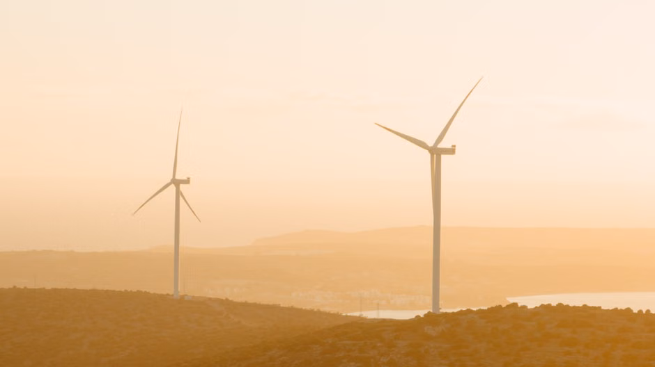 EU Ecolabel for Spas: Sustainability Certification and Requirements A serene sunset view of wind turbines in the rural hills of Çeşme, Türkiye, depicting renewable energy in harmony with nature.